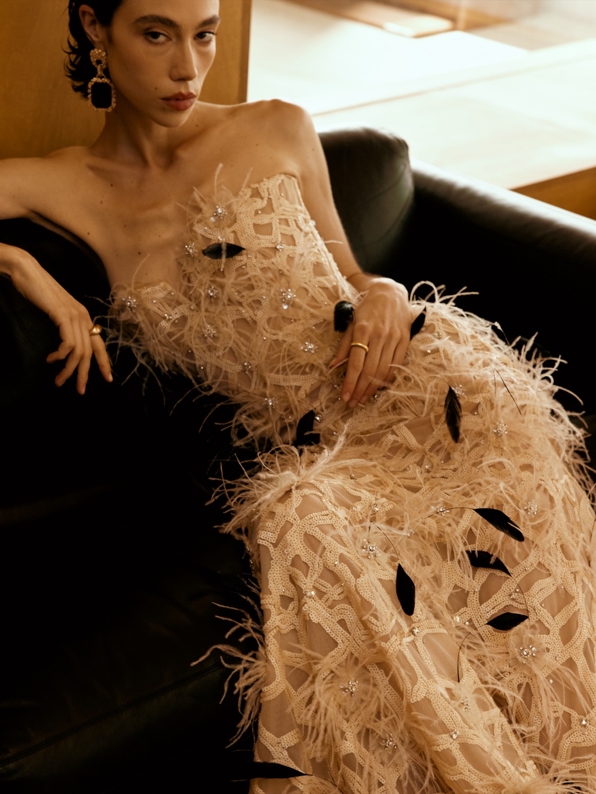 A Lichée Bridal bride in a designer feather gown, reclining in the Bay Area atelier